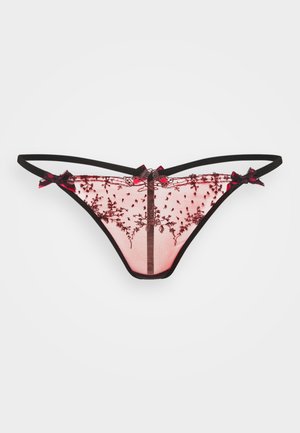 Pink sheer mesh thong with black floral embroidery, black elastic waistband, and small decorative bows on front and sides.
