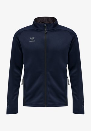 Granatowa kurtka zapinana na zamek, wykonana z miękkiego materiału, z wysokim kołnierzem, bocznymi kieszeniami na zamek oraz kątowymi wzorami na rękawach.