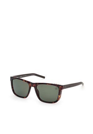 Rechteckige Schildpatt-Sonnenbrille mit dunkelgrünen Gläsern und schwarzen Bügeln, schräg dargestellt, um Vorder- und Seitendetails zu zeigen.