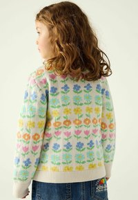 Strickpullover mit Blumenmuster in Creme, ausgestattet mit mehrfarbigen Blumen und grünen Stängeln; gerippte Bündchen und Saum; weiches Material.