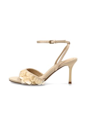 Sandalia de tacón alto para mujer en color beige con correa en el tobillo y lentejuelas redondas decorativas en la tira frontal.