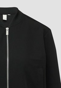 Zwarte bomberjack met een geribde kraag en een rits aan de voorkant. Kenmerkt zich door een solide textuur en zijzakken zonder decoratieve accenten.