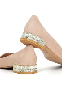 Nude suede ballet flats with a low heel featuring a crystal-accented band and pointed toe design. Smooth texture with a sleek silhouette.
