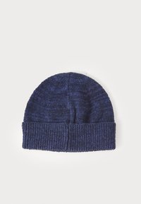 Kootud tumesinine beanie müts, millel on volditud ribiga ääreosa, tekstureeritud muster ja veidi veniv sobivus.