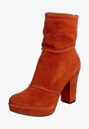 Bottine en daim couleur rouille avec un dessus décontracté, un embout arrondi, une semelle plateforme et un talon haut bloc.
