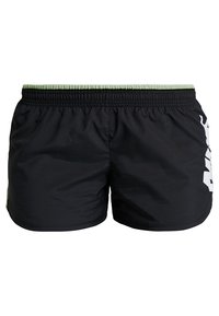 Zwarte zwembroek met een elastische tailleband en een groene accenten. Grote witte grafische afbeelding aan de voorkant en een gladde, lichte stof.
