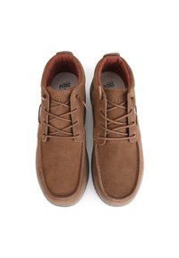 Brown suede shoes with a rounded toe, fabric interior lining, and matching laces. Features a textured rubber sole and branding on the insole.