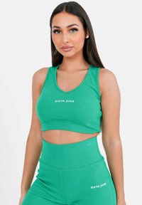 Crop top verde a coste e leggings a vita alta abbinati, con logo "SIXTH JUNE" bianco, texture liscia e design aderente.
