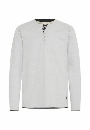 Maglietta henley a maniche lunghe grigio chiaro con tre bottoni al collo, colletto a contrasto nero e rifiniture nere all'orlo. Texture morbida.