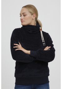 Pullover in pile navy con colletto alto, dotato di lacci decorativi e polsini a coste. Texture morbida con una vestibilità comoda.