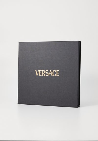 Čierna obdĺžniková škatuľa s textúrovaným povrchom a zlatým nápisom "VERSACE" na prednej strane. Minimalistický dizajn bez ďalších akcentov.