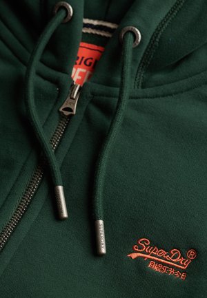 Dark green zipped hoodie with drawstrings featuring metal tips engraved "Superdry" and orange "SuperDry" logo embroidered on fabric.
