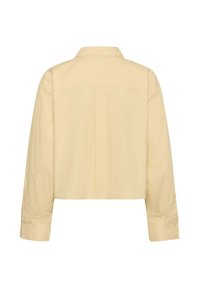 Krótka żółta koszula z lekkiego materiału, z plisą z tyłu, długimi rękawami z mankietami na guziki oraz klasycznym kołnierzykiem.