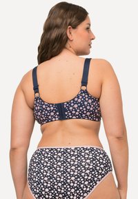 Marineblauwe bikini set met stippen in het roze. De beha heeft verstelbare bandjes en een haaksluiting. Dikke stof met een zachte textuur.