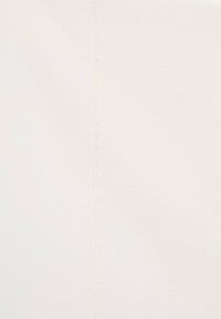 Smooth, textured white fabric with a subtle sheen, featuring a vertical seam with evenly spaced stitching along the side.