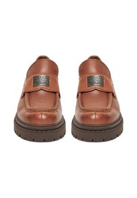 Pár hnedých kožených nazúvacích topánok s masívnymi tmavými podrážkami, na remienku so striebornou kovovou značkou G-Star RAW Originals denim.