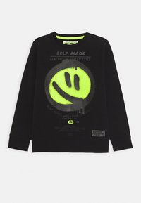 Sudadera negra con un gran gráfico de cara sonriente en neón amarillo, acentos texturizados y detalles de texto impresos en gris. Mangas largas y escote de cuello redondo.