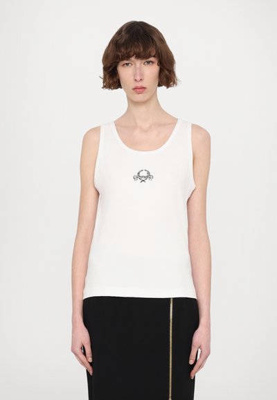 Biała tank top wykonana z prążkowanej tkaniny, z małym haftowanym wzorem w czerni na klatce piersiowej. Bez rękawów, z okrągłym dekoltem.