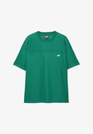 T-shirt vert à manches courtes en tissu texturé, avec un col rond et un petit logo blanc à l'avant.