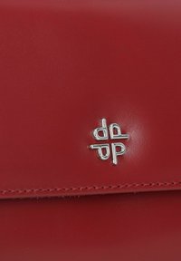 Cartera de cuero rojo con una textura suave y un acento del logo en plateado. Las costuras a lo largo de los bordes añaden detalle al diseño.