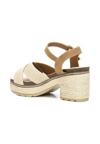Sandali piattaforma intrecciati beige con tacco in stile giuta, design con fascia incrociata e cinturino alla caviglia con chiusura a fibbia.