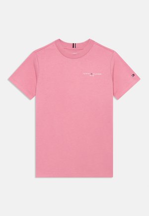 Różowy t-shirt z krótkim rękawem Tommy Hilfiger z małym logo marki na lewej piersi i emblematem flagi na lewym rękawie, rozłożony płasko na białym tle.