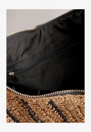 Pletená slamenná taška svetlohnedej farby s čiernymi akcentmi, vybavená čiernym textilným vnútrom a vreckom na zips pre bezpečné uloženie.
