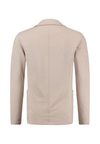 Beige Langarmjacke mit Kragen, sichtbare Naht entlang der Mitte des Rückens und seitlichen Taschen, von hinten auf weißem Hintergrund gezeigt.