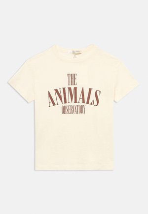 T-shirt court couleur crème avec texte marron "THE ANIMALS OBSERVATORY" sur la poitrine et col rond.
