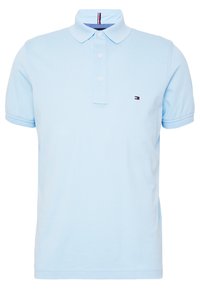 Ljusblå pikétröja i bomull med klassisk krage, treknapplåsning och en liten logotyp på vänster bröst. Korta ärmar.