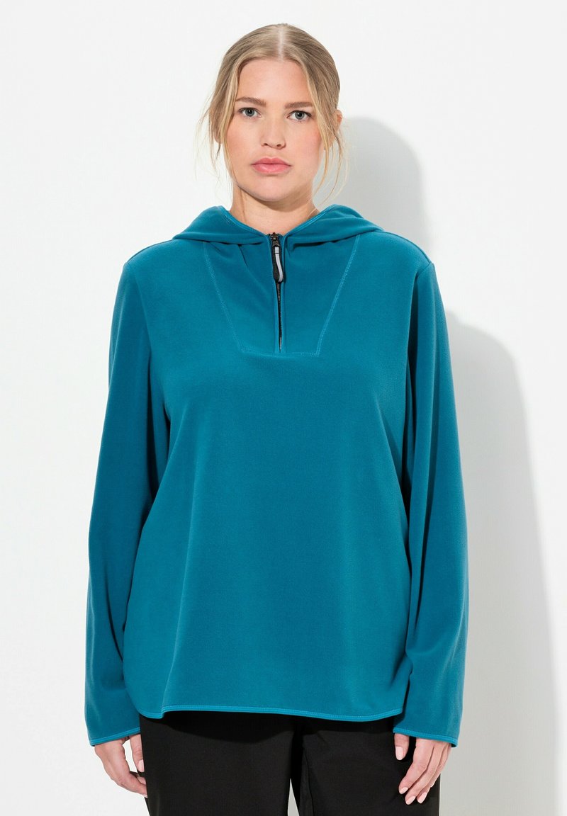 Pullover in pile color teal con cappuccio, dotato di chiusura con zip e scollatura quadrata. Maniche lunghe e vestibilità comoda. Materiale testurizzato.