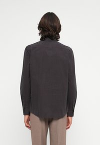 Hosszú ujjú, sötétszürke ing, finom kockás mintával, könnyű anyagból, egyenes szabású, gombos mandzsettával.