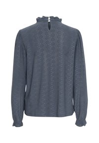 Blusa a maniche lunghe blu, caratterizzata da un motivo testurizzato, colletto arricciato e chiusura a chiave sul retro. Le maniche hanno polsini elasticizzati che completano il design.