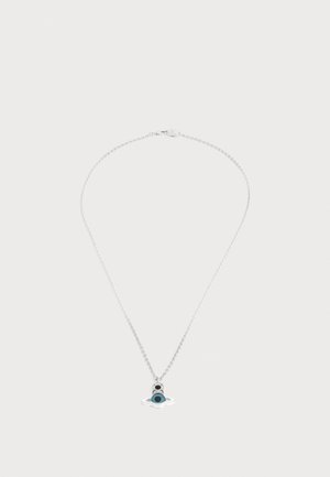 Collier en chaîne argentée avec un petit pendentif présentant un centre turquoise et des détails noirs sur un fond lisse et clair.