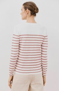 Langsleeve sweater met wit en roségouden strepen, gebreide textuur, ronde halslijn en geribde manchetten. Draagt met lichtbeige broek.