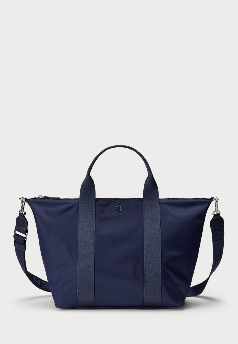 Navy blue tote bag with dual handles, adjustable shoulder strap, top zipper, and small centered logo on front.