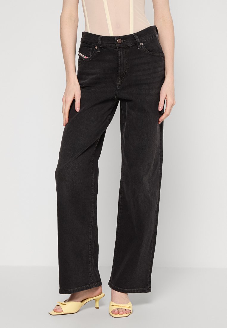 Jeans larghi in denim nero con vita alta, passanti per cintura e tasche frontali con dettagli di cucitura decorativa. Tessuto morbido, design casual.