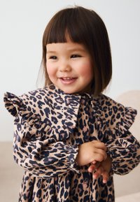 Leopardenmuster Kleid in Beige und Dunkelbraun mit gerafften Ärmeln und durchgehendem Knopfleiste. Besitzt gesammelte Bündchen und eine weiche Textur.