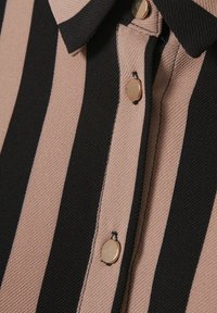 Blusa a righe con strisce orizzontali nere e rosa chiaro, realizzata in un tessuto textured e con bottoni dorati lungo la parte frontale.