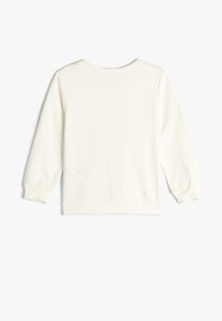 Pullover bianco a maniche lunghe realizzato in morbido cotone. Presenta polsini e fondo a coste, con una texture liscia e un design semplice e pulito.