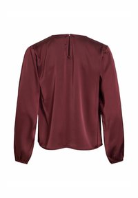 Blouse en satin à manches longues de couleur bordeaux foncé avec une ouverture en forme de trou de serrure au dos et des poignets élastiqués sur fond blanc uni.