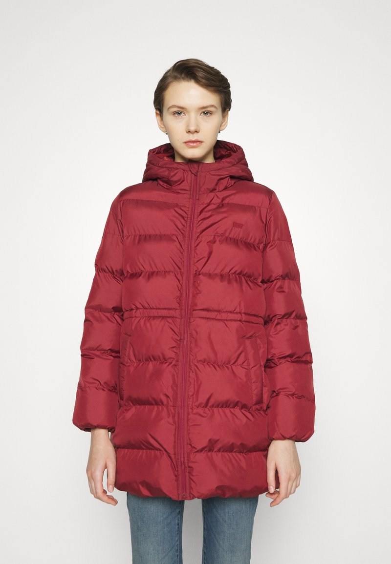 Giacca a vento rossa con cappuccio, caratterizzata da un design trapuntato, chiusura frontale con zip e tasche laterali. Realizzata in material lucido e liscio.