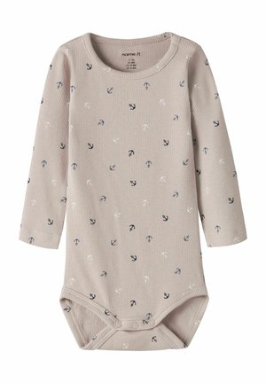 Beige geribbelde babybody met lange mouwen, bedrukt met blauwe, zwarte en witte ankers, en drukknoopsluiting bij het kruis.