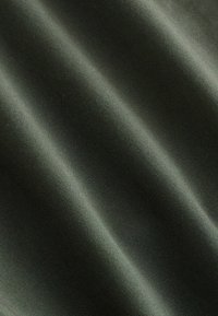 Tessuto verde scuro con una texture liscia, caratterizzato da sottili motivi a coste orizzontali e delicate pieghe, che rappresentano un aspetto morbido e drappeggiato.