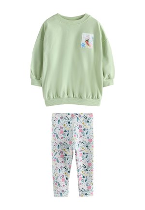 Lysegrøn langærmet sweatshirt med et lille prinsessegrafik på brystet, kombineret med hvide leggings med blomsterprint.
