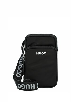Black nylon crossbody bag with two zippered compartments and a detachable strap, featuring white logo text. Compact and rectangular design.