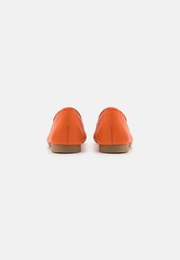 Oranžové kožené ploché boty s hladkým povrchem a zakulacenou špičkou. Minimalistický design s nízkou, neutrálně zbarvenou podešví.