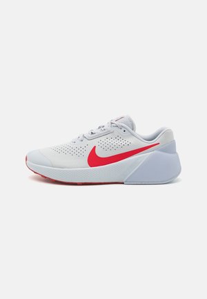 White and red Nike running shoe with breathable perforations, red swoosh logo, and thick cushioned sole on a plain background.
