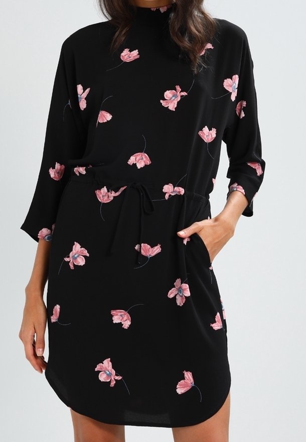 Vestido negro con mangas tres cuartos, estampado floral en tonos rosas, cintura ceñida con un lazo y un corte relajado. Tejido suave con un ligero brillo.