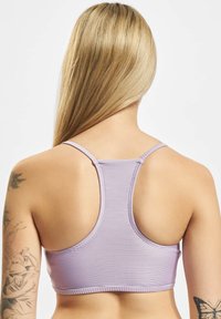 Lilla stripete sports-bh med tynne stropper og racerback-design. Stoffet ser jevnt ut med subtil tekstur og fleksibilitet.